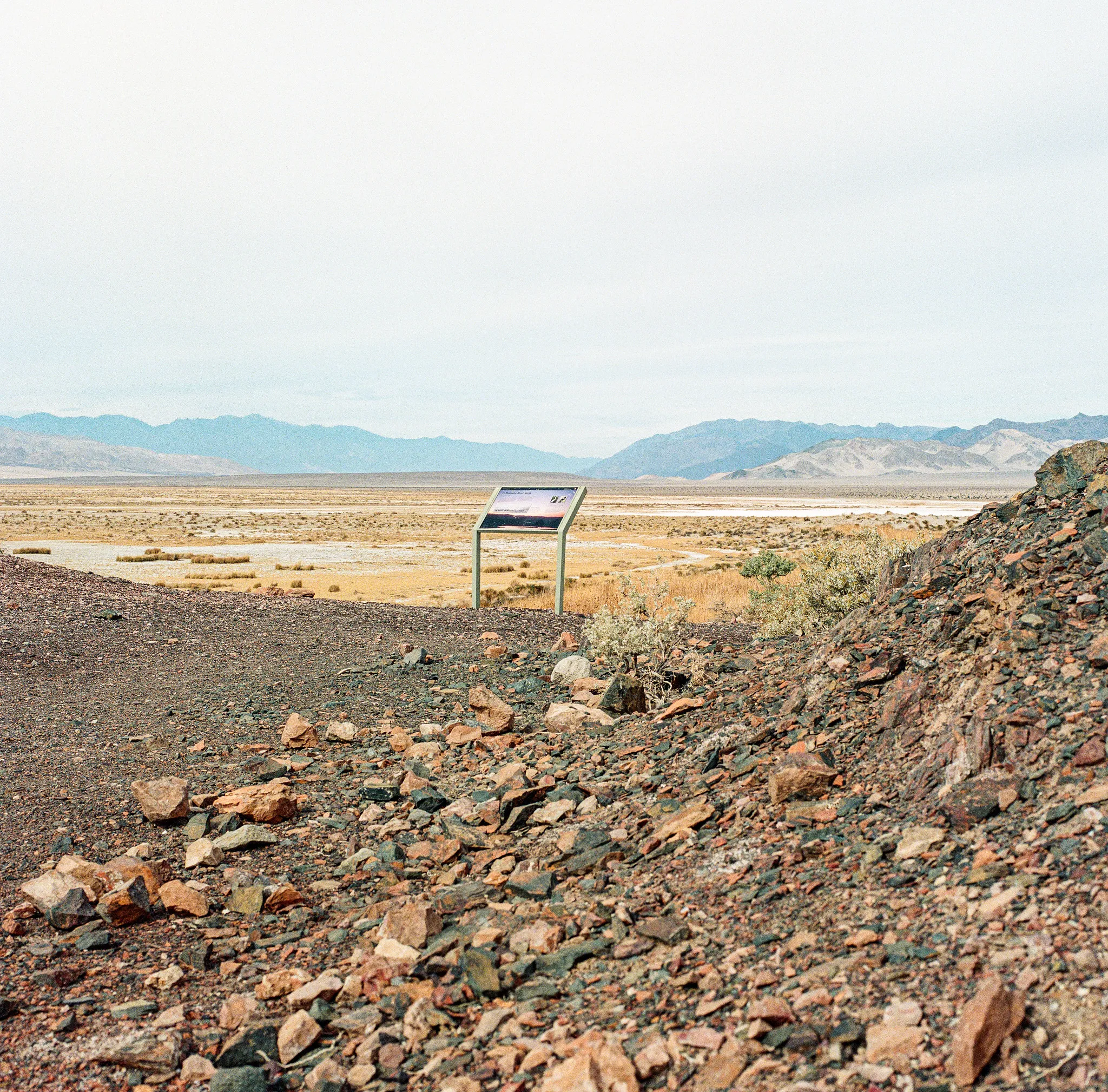 Interpretive sign overlooking a vast desert basin with distant mountains