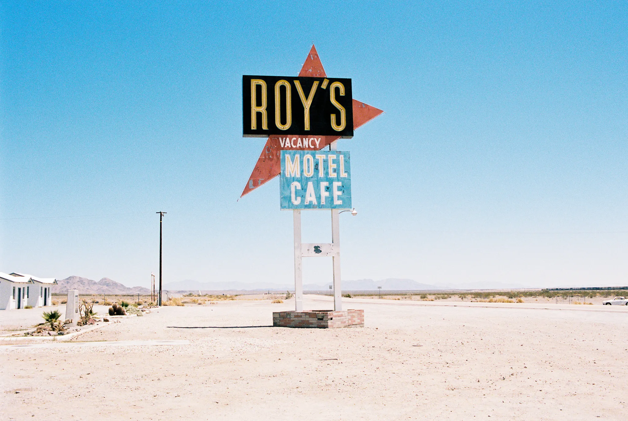 Iconic Roy's Motel and Cafe neon sign against clear blue desert sky